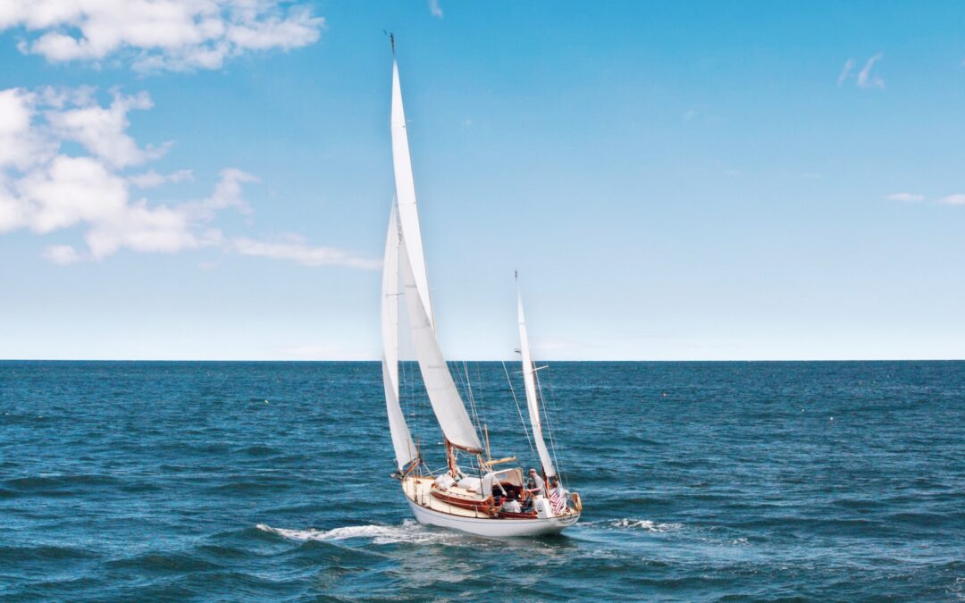 white sail boat on body of wate