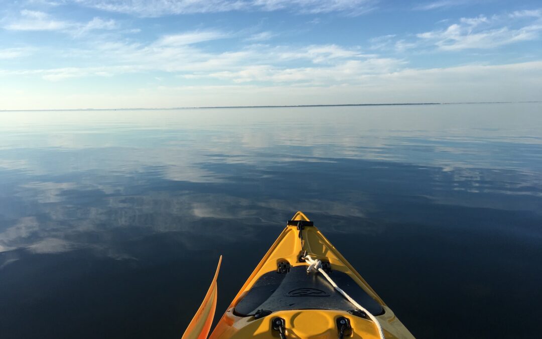 photography of yellow kayak sailing on body of water