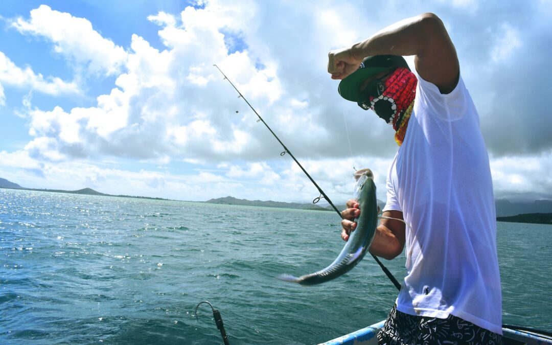 man in white t-shirt holding a fish