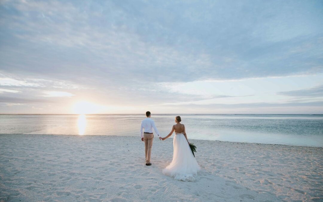 man and woman walking on beach during daytime